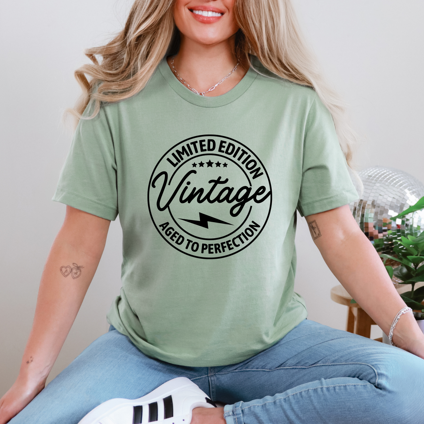 A person wearing a green graphic t-shirt with the text 'LIMITED EDITION Vintage' printed on it.