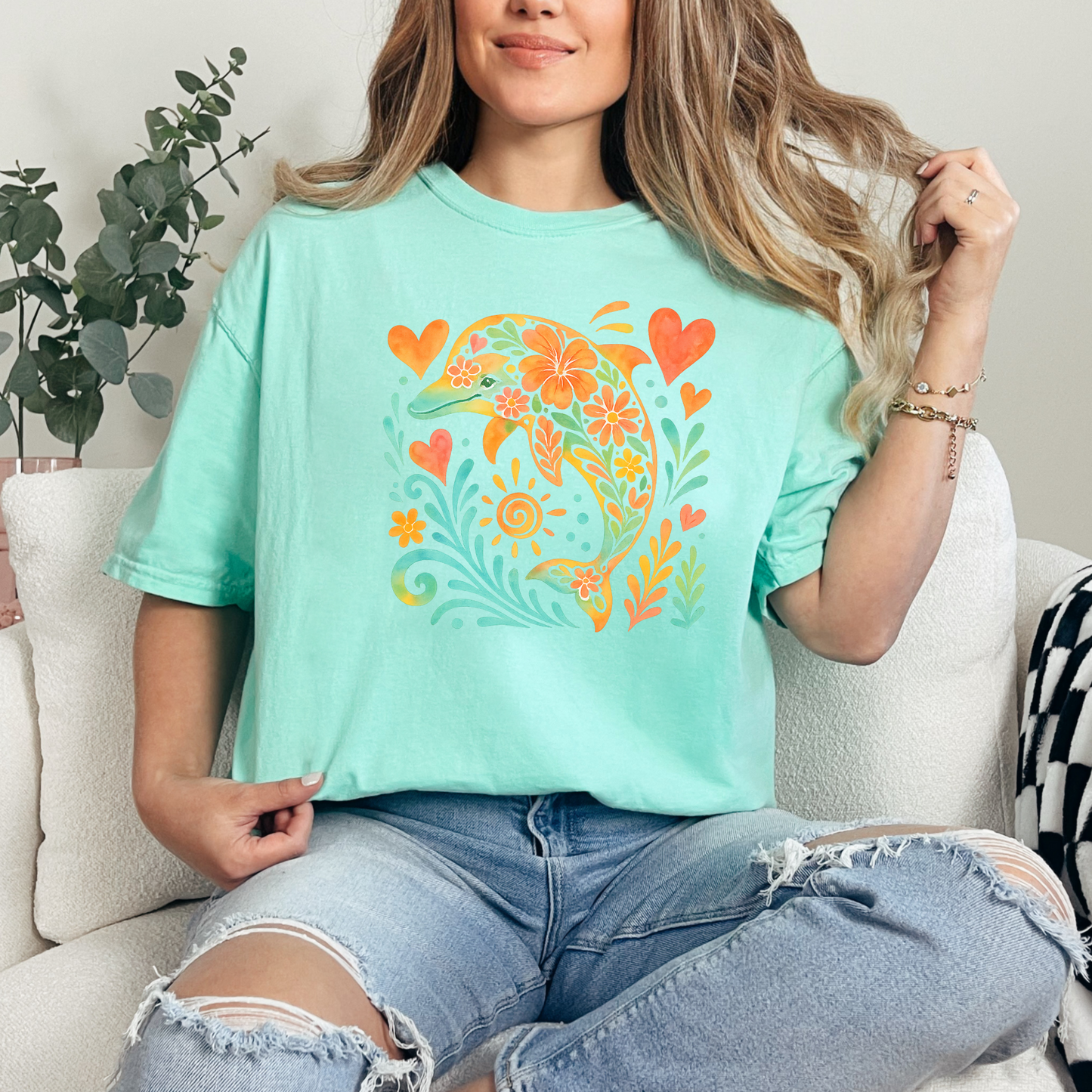 Person wearing a light blue graphic t-shirt with a colorful dolphin design.