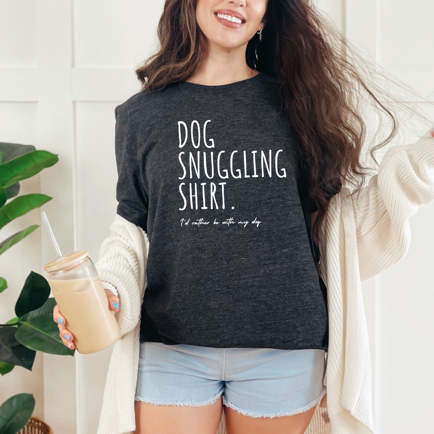 A person wearing a gray t-shirt with the text 'DOG SNUGGLING SHIRT. I'd rather be with my dog.